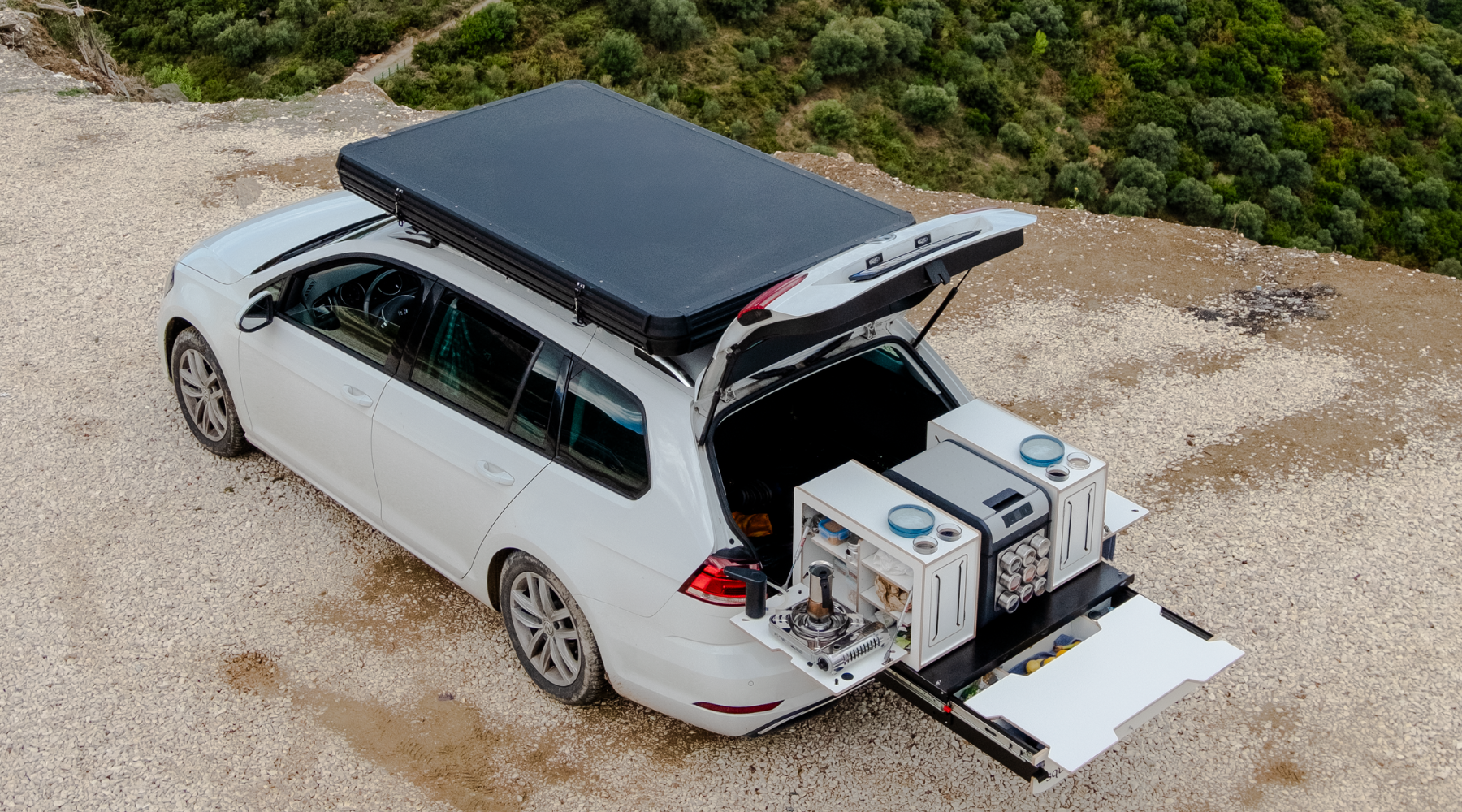 Auto mit Heckauszug und Dachzelt an der Straße