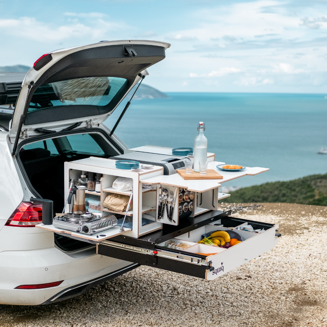 Autocamping direkt am Meer mit squiq Heckauszug, integrierter Campingküche und Campingboxen im VW Golf Variant. Kocher, Wasserversorgung und Proviant befinden sich übersichtlich im Kofferraumauszug.