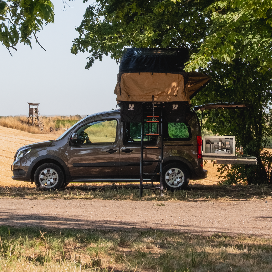 SQUIQ uitschuifsysteem in de hoge dakcombi met campingbox en daktent in het bos voor een veld