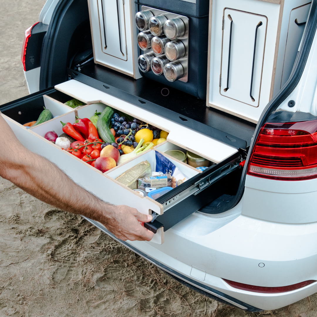 Campingsysteem in de auto als uitschuifsysteem met levensmiddelen en campingboxen