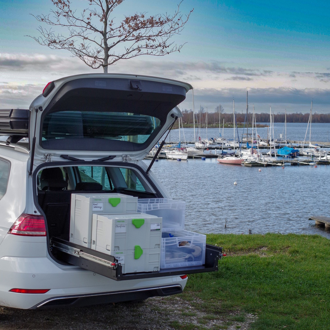 Heckauszug im PKW mit ausziehbarem Ladeboden und Kisten im Kofferraum