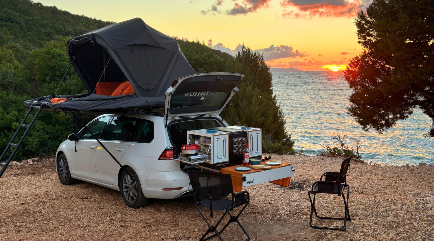 dachzelt mit heckauszug und tisch vor sonnenuntergang panorama am strand