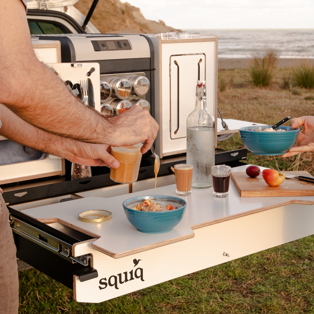 Kofferraumauszug mit Campingboxen am Strand - Frühstück mit der mobilen Heckküche für Autos