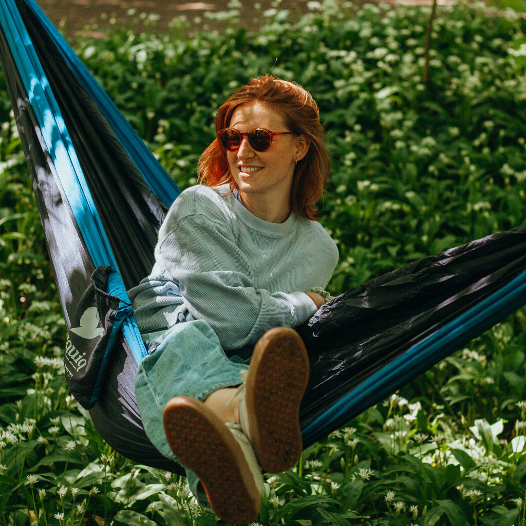 hängematte im wald mit person mit sonnenbrille