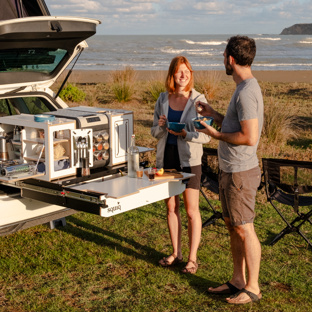 squiq Kofferraumauszug als Heckauszug mit Camping Box und integrierter Heckküche, zwei Personen frühstücken am Autocamper