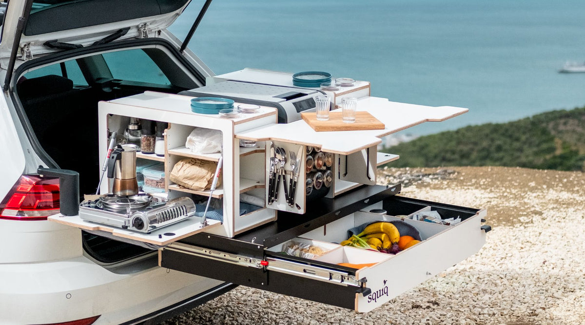 Campingbox in de kofferbak als modulair uitschuifsysteem met kooktoestel, bestek en watervoorziening aan zee