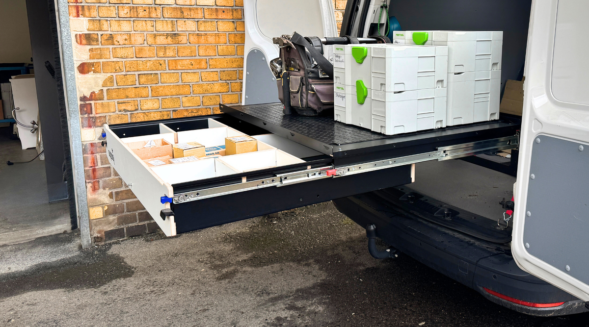 Uitschuifsysteem als voertuiginrichting in de personenauto met gereedschap op het laadvlak als werkplaatsinrichting in de auto
